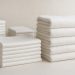 Stacks of crisp white folded hotel linen and towels ready for delivery