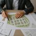A town planning consultant reviewing architectural blueprints and site plans