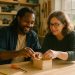 Two adults working together at a bench in a bright community workshop